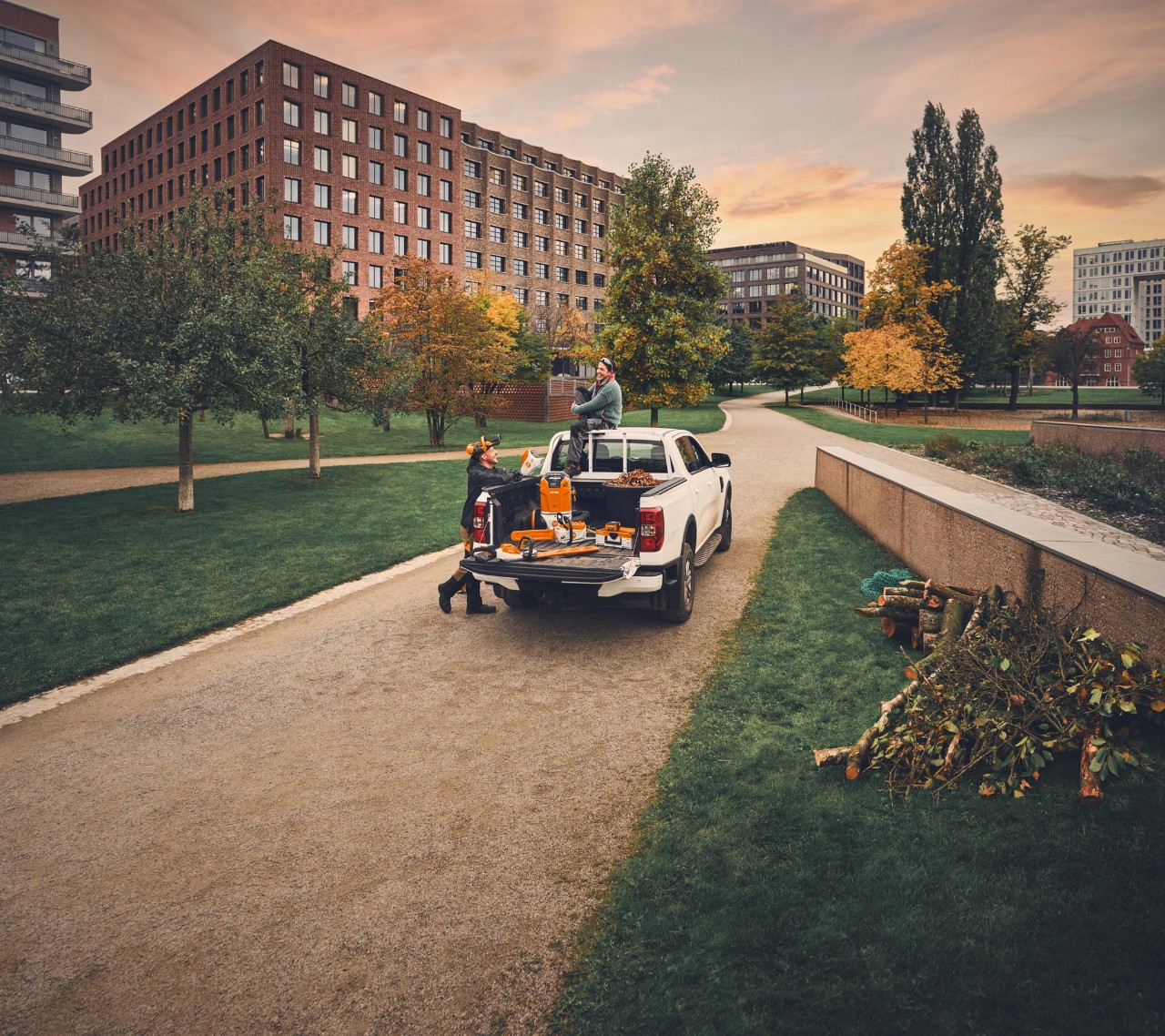Professional users handle STIHL cordless tools in a truck bed in a park