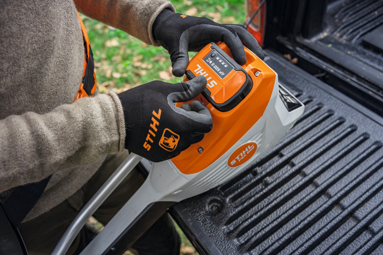 Inserting a STIHL AP 500 S battery into a device.
