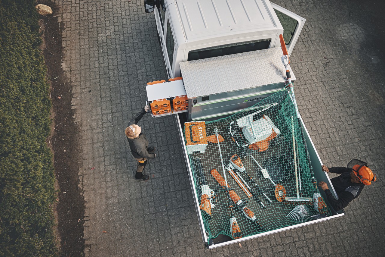 Overhead view of two STIHL professionals on a vehicle loaded with a bottTainer and STIHL cordless power tools.