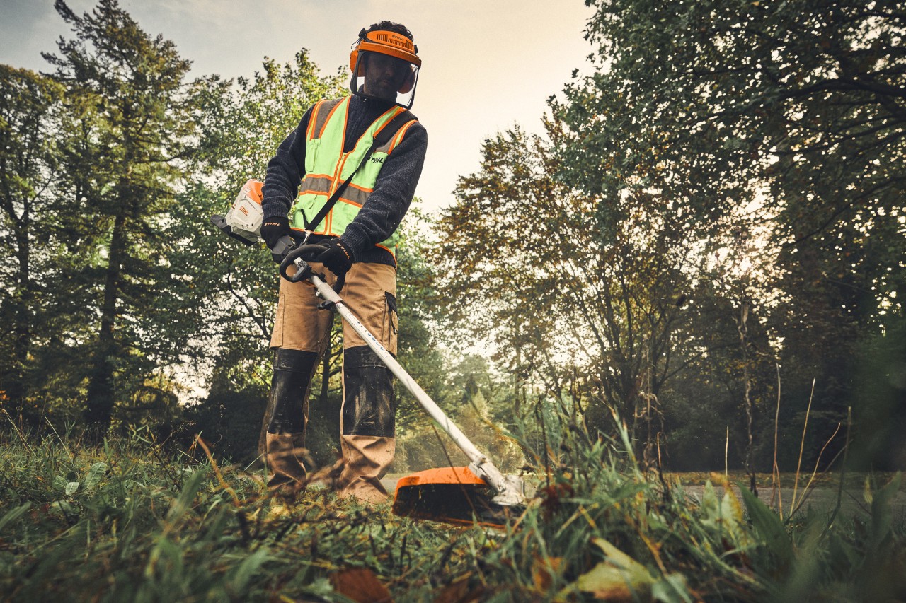 A man with a STIHL KMA 200 R and FS-KM KombiTool