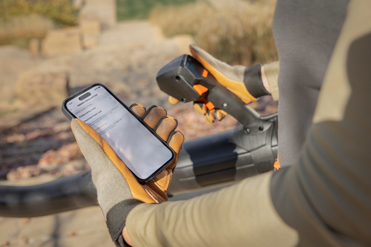 Landscaper with blower and smartphone with connected screen