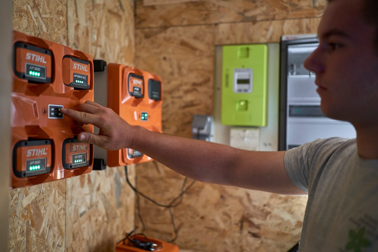 A man standing at a battery charging station