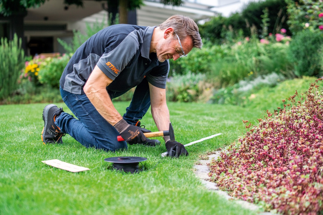 A STIHL dealer laying perimeter wire.